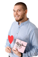 Young happy man holding red paper heart.