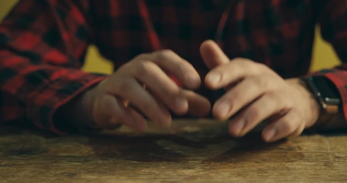 Nervous man tapping fingers on table