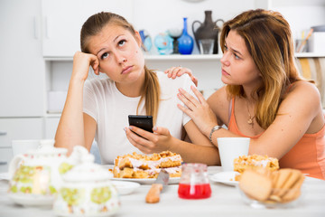 Obraz na płótnie Canvas female talking with sad friend with mobile