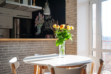 Yellow roses in a glass vase on the table. Holidays and celebration concept.