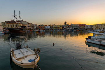 Fototapeta na wymiar Greece, Crete Rethymnon. Old venetian harbor at the sunset. Panoramic view on the port and sailing ship.