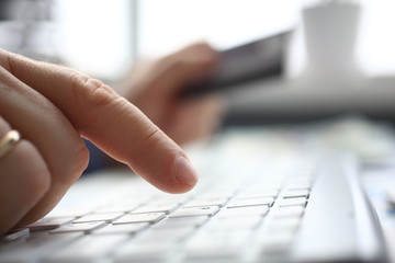 Male arms in suit typing on silver keyboard using