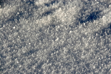 Weiße Eis-Kristalle glitzern als Nahaufnahme im Winter in der Sonne, der Frost war da