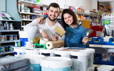 Couple purchasing tools for house improvements in paint supplies store