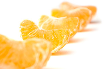 pieces of peeled tangerine alignment on white background