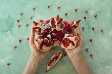 Hands to break the pomegranate fruit. Top view. 

