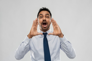 business, stress and people concept - indian businessman shouting or calling over grey background