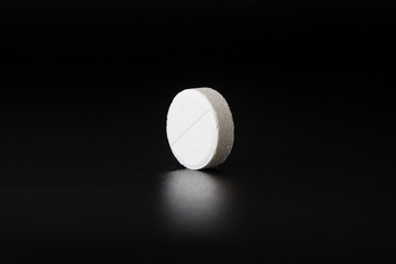 Fototapeta na wymiar White medical pills on black background