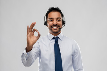 business, customer service and people concept - smiling indian businessman or helpline operator in...