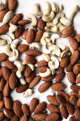 Natural background made in nuts. Cashews and almonds on white background.