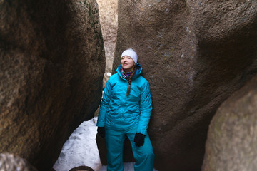 girl in blue sportswear in the crevice in the middle of the rock. Active lifestyle, hiking