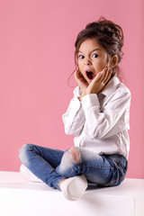Cute surprised little girl in white shirt with hairstyle