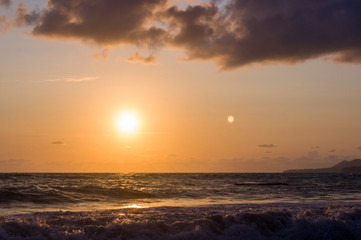 Naklejka na ściany i meble Amazing sea sunset, the sun, waves, clouds