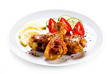 Drumsticks with vegetables on white background