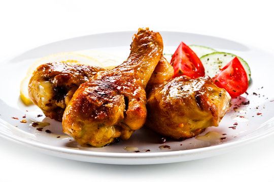 Drumsticks with vegetables on white background