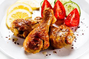 Drumsticks with vegetables on white background