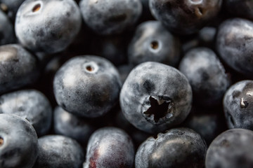 Ripe tasty blueberries and berries on a wooden table in a bowl