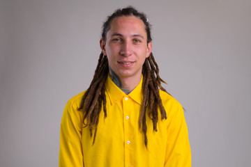 Face of young happy businessman with dreadlocks smiling