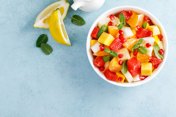 Healthy vegetarian fresh fruit salad with apple, pear, tangerine, grapefruit, mango, pomegranate and lemon juice