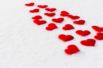 Red hearts on glittering snow. Vilentine's day theme. Copy space