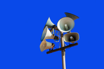 Set of street loudspeakers on a pole on a background blue sky