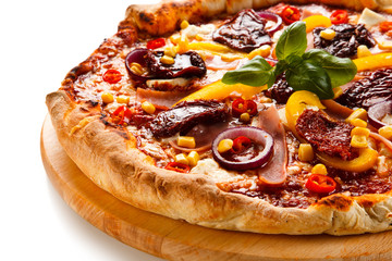 Pizza with ham, corn, mushrooms and dried tomatoes on white background