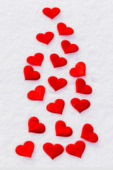Red hearts on glittering snow. Vilentine's day theme.
