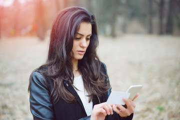 Attractive woman with credit card shopping online in the park