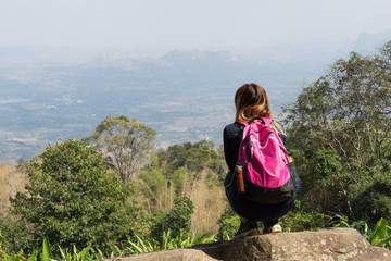 Naklejka premium Asian woman with pink backpack sitting looking at mountain view