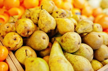 Colorful shiny fresh fruits. Pears on the shelf of a supermarket or grocery store.