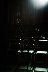 Microphone in front of empty rows in small dark hall