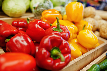 Colorful shiny fresh vegetables. Bell sweet yellow and red peppers on the shelf of a supermarket or grocery store.