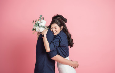 woman hugging her boyfrienfd with bouquet in hand