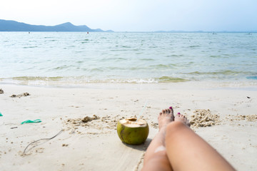 Summer holidays on the Phu Quoc island with coconut,legs and sea on beautiful white sand with crystal clear sea as a travel concept background