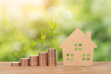 Model house and coin stack on white background mortgage saving concept