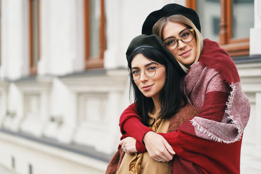Two friends in casual warm outfits outdoors portrait