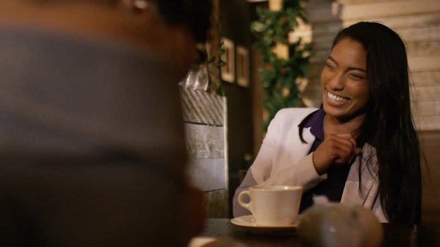 Two women in a coffee shop chatting and laughing