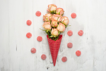 Pink roses in a red cone with ice cream on a marble background, concept gift for the beloved festive background, anniversary, wedding, Valentine's Day.Flat lay.top view, copy space