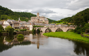 Obraz premium Estaing and its medieval castle reflected in the calm waters of the river Lot