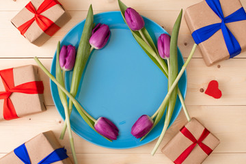 pink tulips in a plate with romantic gifts around
