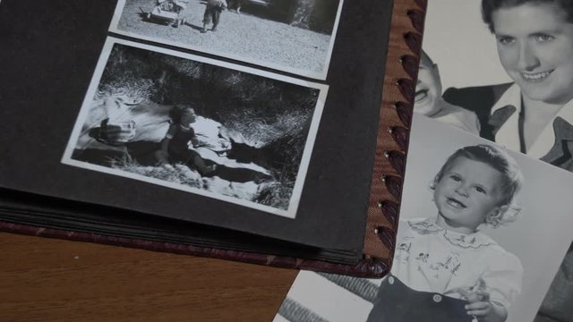 Foreground slow motion of Browsing a vintage photo album with family in Italy