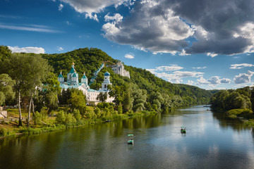 Fototapeta na wymiar Boats on the Seversky Donets river, Holy Mountains and Sviatogorskaya Lavra at Sviatogorsk.