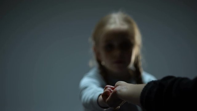 Little child accepting adult helping hand, social security concept, charity
