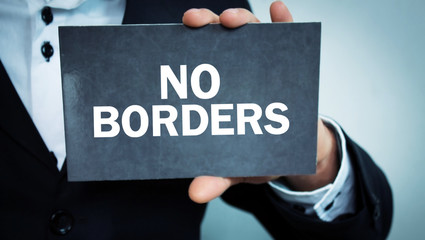 Man showing No Borders text in cardboard.
