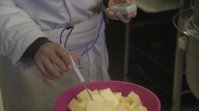 Panadero que mide la temperatura de la mantequilla