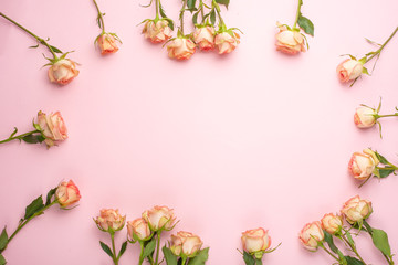 Valentine's Day. Frame made of rose flowers on a pink background. Valentine's day background. Flat lay, top view, copy space