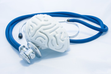 Model of human brain with convolutions and blue stethoscope are on white uniform background....