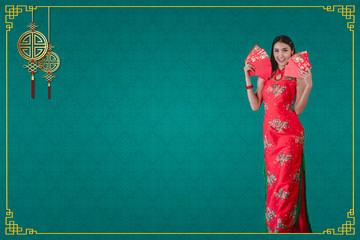 Asian woman in cheongsam dress holding angpao Happy chinese new year  on green background