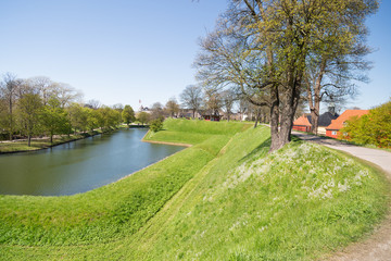 Canal and the prison complex on the rear side of the church in citadel Kastellet, one of the best preserved star fortresses in Northern Europe. Copenhagen, Denmark. Spring.
