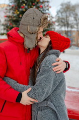 Happy Young Couple in Winter Park laughing and having fun. Family Outdoors. Beautiful man with beard and beautiful girl brunette model together